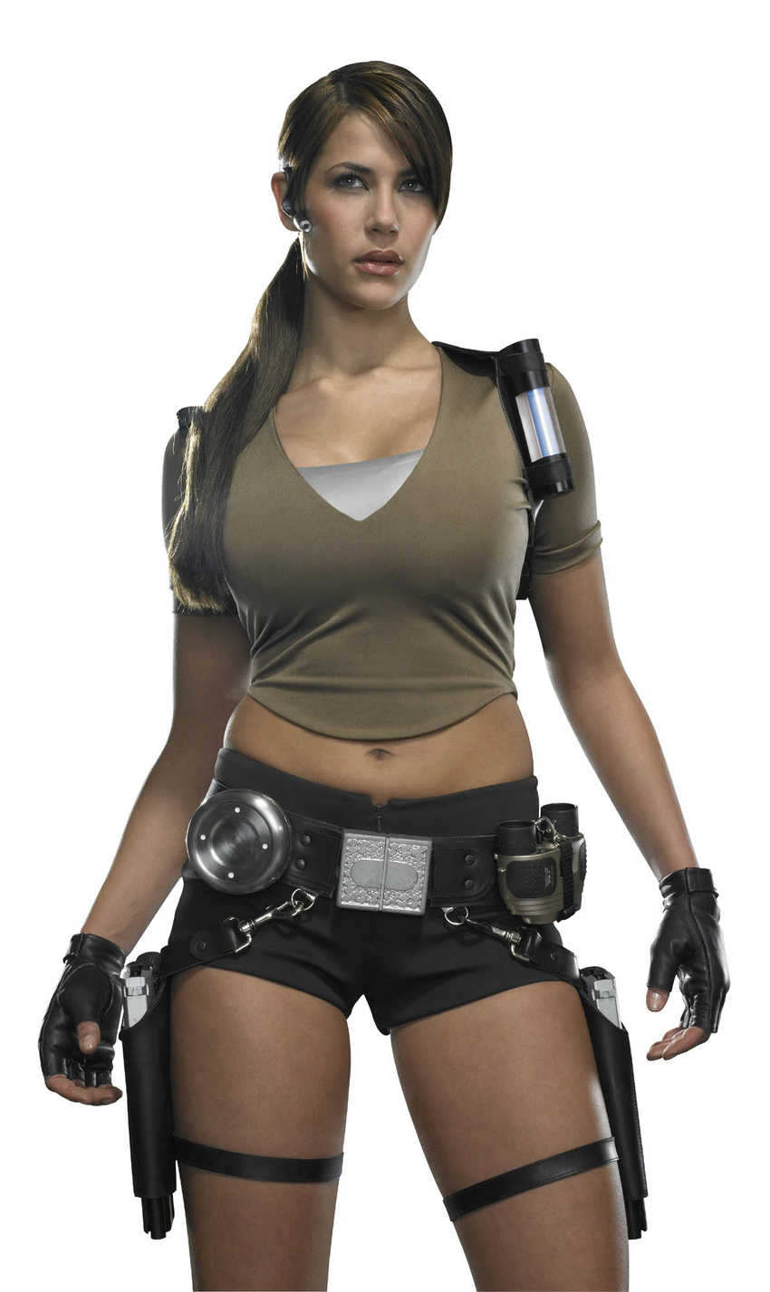 bike_shorts breasts brown_hair cleavage cosplay female fingerless_gloves girl gloves gun karima_adebibe lara_croft large_breasts legs midriff navel photo pistol ponytail shirt shorts solo standing tomb_raider weapon