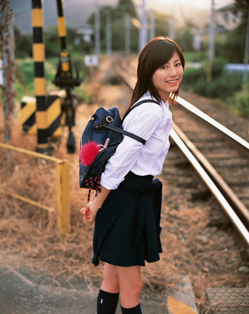 1girl asian brown_hair cosplay highres knee_socks kneehighs long_hair looking_at_viewer miniskirt photo pleated_skirt railroad_crossing railroad_tracks school_bag school_uniform serafuku skirt socks solo standing sugimoto_yumi train_tracks