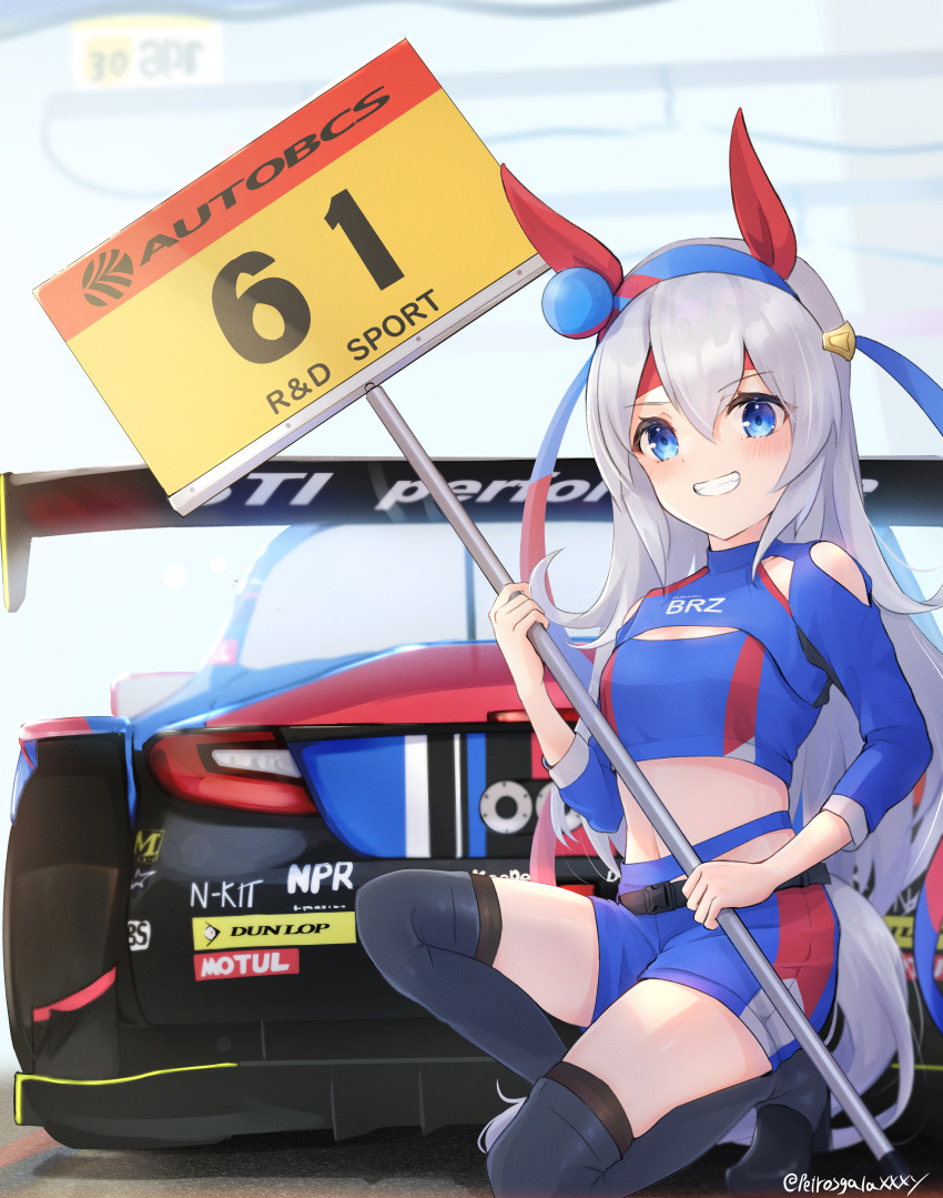 1girl absurdres alternate_costume animal_ears belt black_footwear blindfold blue_eyes blue_shirt blue_shorts boots breasts car clothing_cutout crop_top grey_hair grin hairband headband highres holding holding_sign horse_ears horse_girl horse_tail long_hair looking_at_viewer midriff motor_vehicle navel on_one_knee peteron race_queen race_vehicle racecar shirt shorts shoulder_cutout shrug_(clothing) sign small_breasts smile snap-fit_buckle solo tail tamamo_cross_(umamusume) thigh_boots twitter_username umamusume