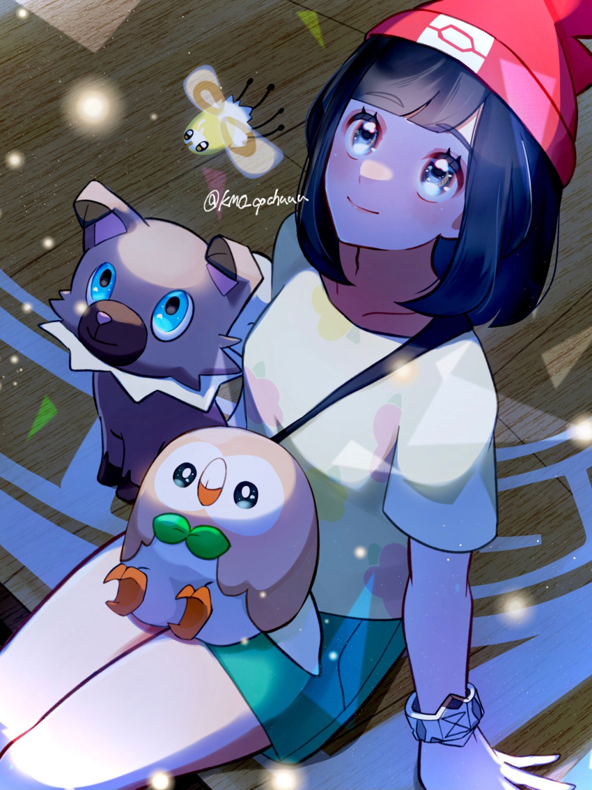 1girl arm_support beanie black_hair closed_mouth commentary_request cutiefly eyelashes green_shorts grey_eyes hat highres kamicho_musharu looking_up medium_hair on_lap pokemon pokemon_(creature) pokemon_on_lap pokemon_sm rockruff rowlet selene_(pokemon) shirt short_sleeves shorts sitting smile strap twitter_username yellow_shirt z-ring