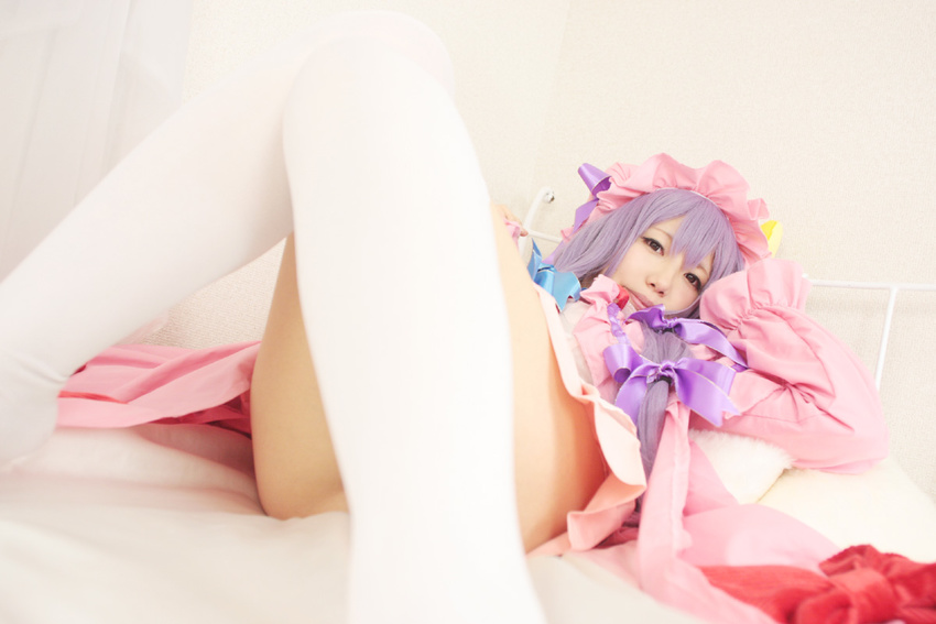 1girl asian bed cosplay crescent dress female hat long_hair patchouli_knowledge photo pillow purple_hair solo tenshi_myu touhou