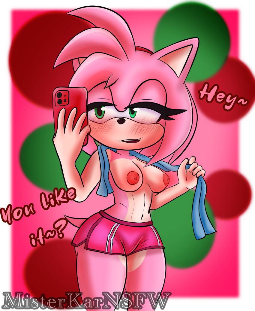 2023 absurd_res amy_rose anthro blush bottomwear breasts clothed clothing electronics english_text eulipotyphlan exposed_breasts female green_eyes gym_bottomwear gym_clothing gym_shorts hedgehog hi_res holding_object holding_phone mammal medium_breasts misterkarnsfw navel nipples phone sega shorts signature solo sonic_the_hedgehog_(series) text topless topless_female towel
