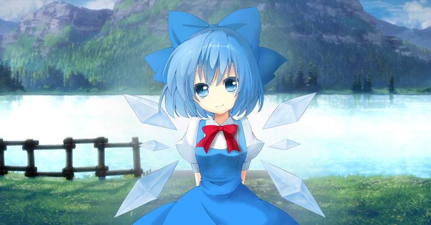 arms_behind_back blue_eyes blue_hair blush bow bowtie ci_fang_wu cirno dress fairy_wings fence hair_ribbon head_tilt highres ice ice_wings lake looking_at_viewer mountain nature puffy_short_sleeves puffy_sleeves red_bow red_neckwear ribbon scenery short_hair short_sleeves smile solo touhou water wings