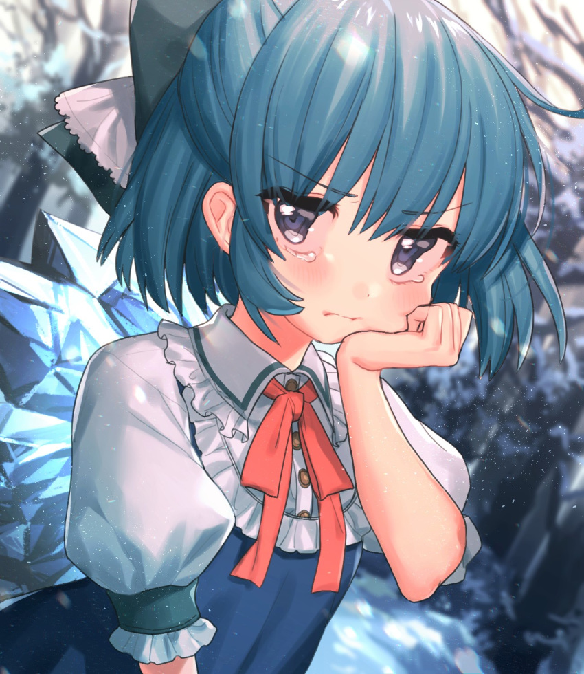 1girl bangs bare_tree blue_bow blue_dress blue_eyes blue_hair blurry blurry_background blush bow cirno commentary_request dress eyebrows_visible_through_hair frilled_shirt_collar frills hair_between_eyes hair_bow hand_on_own_cheek hand_up highres ice ice_wings light_particles looking_at_viewer masanaga_(tsukasa) neck_ribbon pinafore_dress red_neckwear red_ribbon ribbon shirt short_hair snow solo tears touhou tree upper_body white_shirt wings