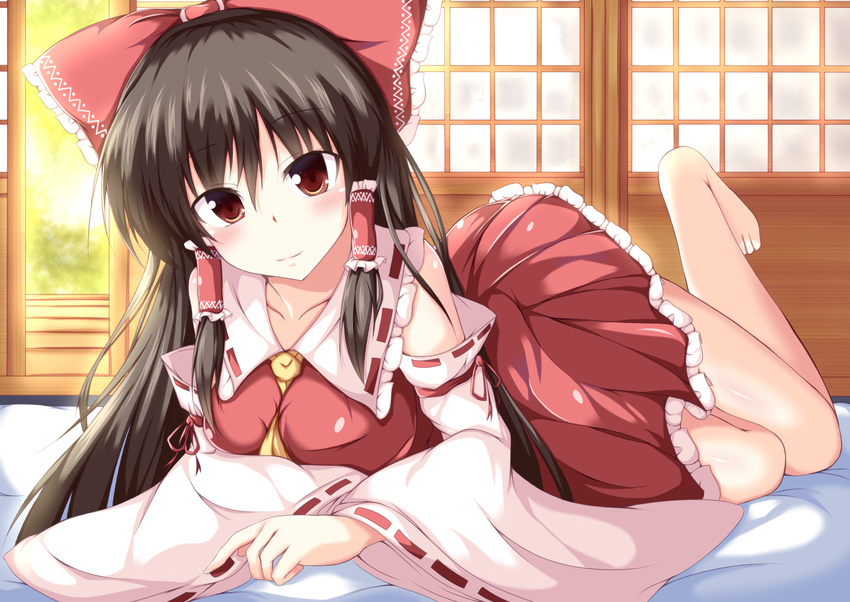 ascot barefoot between_breasts black_hair blush bow breasts brown_eyes collarbone commentary_request detached_sleeves dress futon hair_bow hair_tubes hakurei_reimu highres large_breasts leg_up long_hair long_sleeves looking_at_viewer lying naba_(take_tonbo) on_stomach open_clothes open_dress red_dress smile solo touhou wide_sleeves