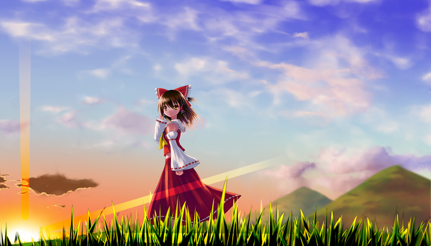 ascot bow brown_hair clenched_hand cloud detached_sleeves grass hair_bow hair_tubes hakurei_reimu hand_behind_head highres lens_flare looking_at_viewer midriff mountain noronosuke orange_eyes short_hair skirt skirt_set sky solo sunset touhou