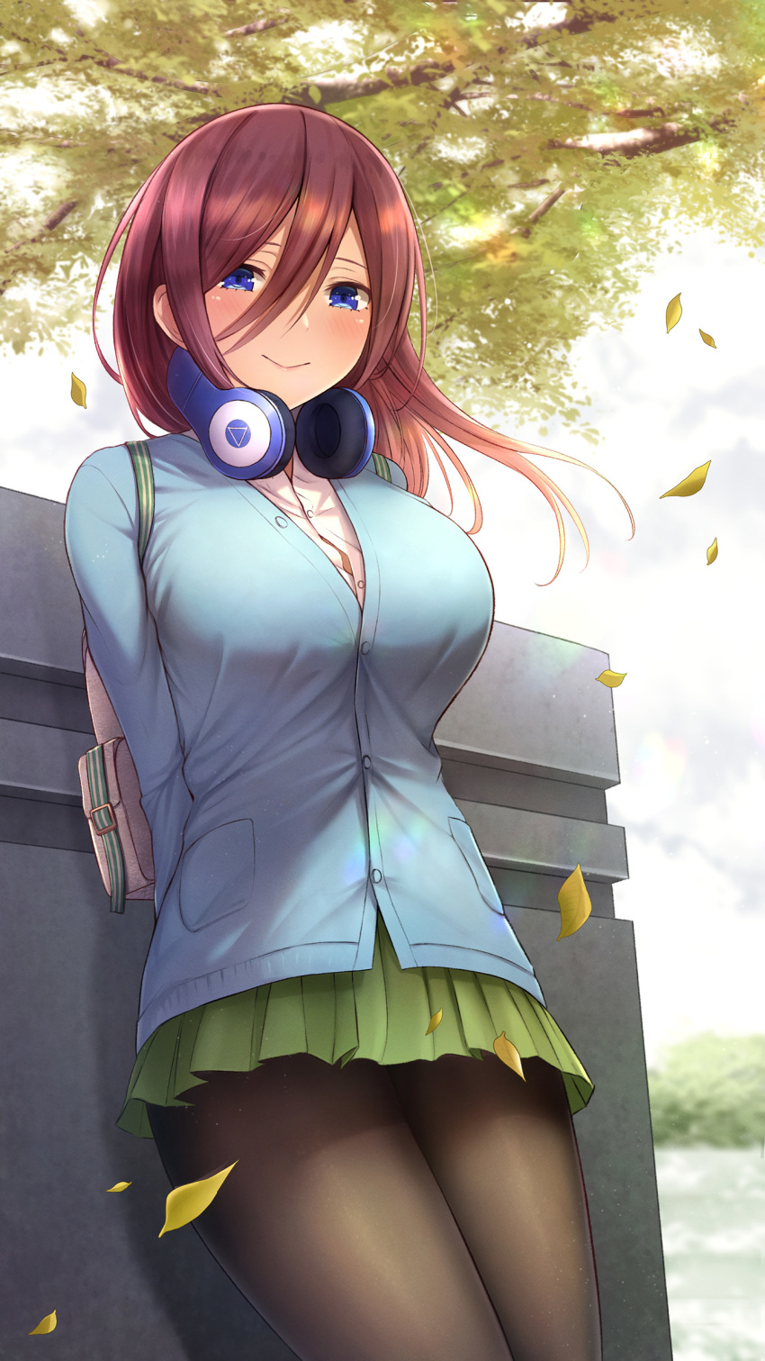 1girl absurdres arms_behind_back bag bangs black_legwear blue_cardigan blue_eyes blush breasts brown_hair closed_mouth collared_shirt day eyebrows_visible_through_hair floating_hair fou_zi go-toubun_no_hanayome green_skirt hair_between_eyes headphones headphones_around_neck highres large_breasts leaning leaves_in_wind light_particles long_hair long_sleeves looking_at_viewer nakano_miku outdoors pantyhose pleated_skirt school_bag school_uniform shirt sidelocks skirt smile solo uniform white_shirt wind