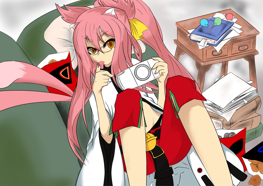 akamado animal_ears belt blazblue book candy capri_pants food glasses handheld_game_console highres kokonoe lollipop long_hair orange_eyes pants pink_hair playstation_portable red_pants slit_pupils solo tail tongue