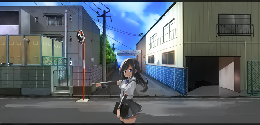arm_warmers asashio_(kantai_collection) black_hair blue_eyes cityscape clipboard commentary_request from_side highres kantai_collection lamppost long_hair looking_back looking_to_the_side outdoors pleated_skirt pointing pointing_forward road school_uniform shirt short_sleeves skirt smile solo street suspenders uni_mate