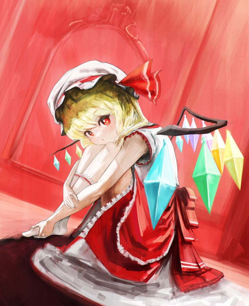 1girl absurdres adapted_costume blonde_hair crystal dutch_angle flandre_scarlet frilled_skirt frilled_socks frills full_body hat highres hugging_own_legs indoors leaning_forward looking_at_viewer medium_hair mob_cap multicolored_wings nepperoni no_vest red_background red_eyes red_skirt shirt skirt socks solo touhou white_headwear white_shirt white_socks wings