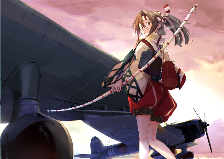 aircraft airplane bow_(weapon) brown_eyes brown_hair d3a from_below frown headband high_ponytail kantai_collection long_sleeves looking_back solo sunrise takeshima_satoshi weapon wide_sleeves zuihou_(kantai_collection)