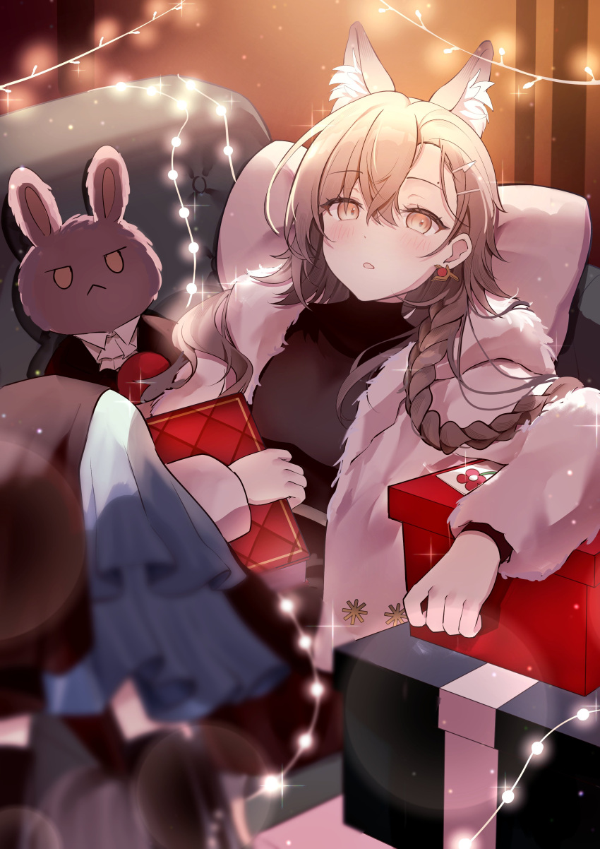 1girl absurdres animal_ear_fluff animal_ears arknights black_sweater box braid brown_hair commentary couch fur-trimmed_jacket fur_trim gift gift_box highres jacket light_particles long_hair long_sleeves looking_at_viewer official_alternate_costume on_couch parted_lips penance_(arknights) penance_(occasionally_flushed)_(arknights) pillow shan_(ti0n) single_braid solo stuffed_animal stuffed_toy sweater white_jacket wolf_ears yellow_eyes