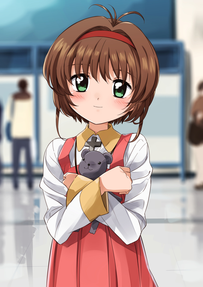 1girl absurdres bangs blurry blurry_background blush brown_hair cardcaptor_sakura closed_mouth collared_shirt commentary_request cross crossed_arms depth_of_field dress eyebrows_visible_through_hair green_eyes hair_intakes hairband head_tilt highres indoors kinomoto_sakura long_sleeves looking_at_viewer mousou_(mousou_temporary) object_hug pleated_skirt red_dress red_hairband shirt short_hair skirt smile solo_focus stuffed_animal stuffed_toy teddy_bear white_shirt