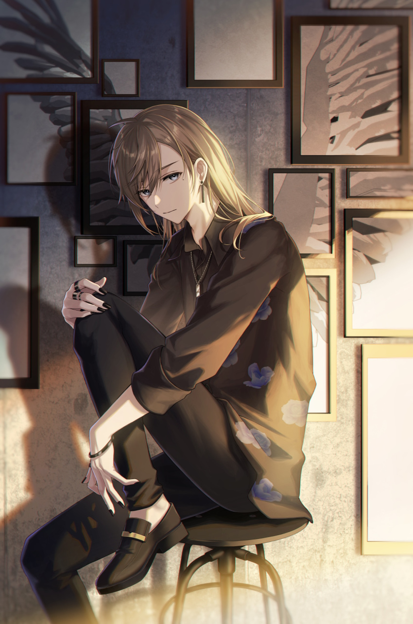 1boy alternate_hairstyle black_footwear black_nails black_pants blue_eyes bracelet brown_hair brown_shirt cloud_print commentary foot_out_of_frame highres hugging_own_legs jewelry kanae_(14th_costume)_(nijisanji) kanae_(nijisanji) kawausoman knee_up long_hair long_sleeves looking_at_viewer male_focus medium_hair mole mole_under_eye multiple_rings nail_polish necklace nijisanji pants picture_frame ring shadow shirt sitting solo stool virtual_youtuber