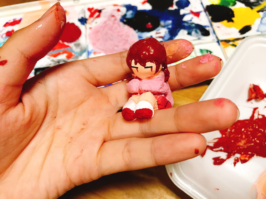 bangs braid brown_hair clay clay_(medium) commentary_request eguchi_saan hands highres holding long_sleeves looking_to_the_side madotsuki paint paint_(medium) pink_shirt red_eyes red_footwear sculpture shirt sitting socks solo twin_braids white_legwear yume_nikki