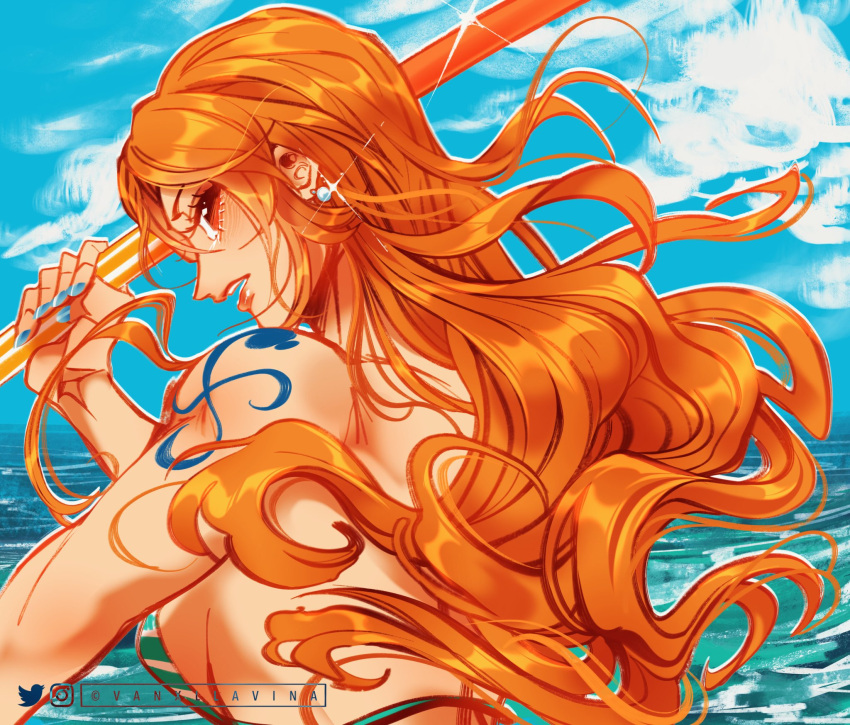 1girl arm_tattoo bikini bikini_top_only blue_nails commentary earrings floating_hair highres holding holding_stick instagram_username jewelry long_hair looking_back nami_(one_piece) ocean one_piece orange_eyes profile sky solo stick swimsuit tattoo twitter_username upper_body vanxllavina