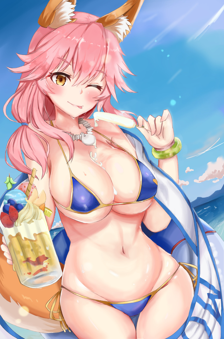 1girl ;p absurdres animal_ear_fluff animal_ears bangs between_breasts bikini blue_bikini blush breasts cleavage closed_mouth collarbone cowboy_shot day eyebrows_visible_through_hair fate/grand_order fate_(series) food fox_ears fox_girl fox_tail groin hair_between_eyes highres holding holding_food ice_cream innertube jewelry large_breasts long_hair looking_at_viewer midriff navel necklace ocean one_eye_closed oni_no_shura outdoors pink_hair popsicle shiny shiny_skin side-tie_bikini sidelocks skindentation smile solo standing stomach sweat swimsuit tail tamamo_(fate)_(all) tamamo_no_mae_(swimsuit_lancer)_(fate) thigh_gap tongue tongue_out yellow_eyes