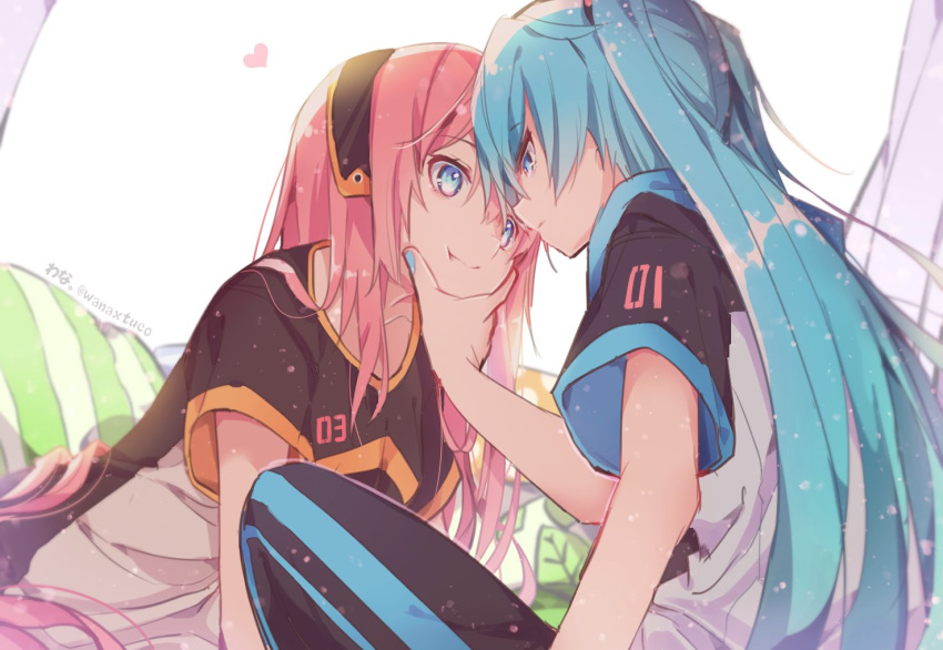 2girls :t blue_eyes blue_hair commentary eye_contact hand_on_another's_chin hatsune_miku head_to_head headband heart leaning_forward long_hair looking_at_another megurine_luka multiple_girls nail_polish pants pillow pink_hair short_sleeves sitting straight_hair track_pants twintails twitter_username very_long_hair vocaloid wanaxtuco yuri