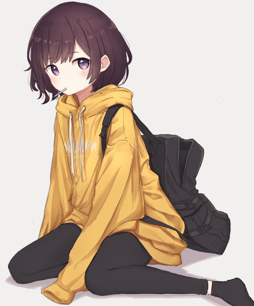 1girl backpack bag bangs black_legwear blush brown_hair candy clothes_writing commentary_request drawstring eyebrows_visible_through_hair food food_in_mouth highres hood hood_down leggings lollipop long_sleeves looking_at_viewer mouth_hold original purple_eyes short_hair sitting sleeves_past_fingers sleeves_past_wrists socks yellow_hoodie zuima