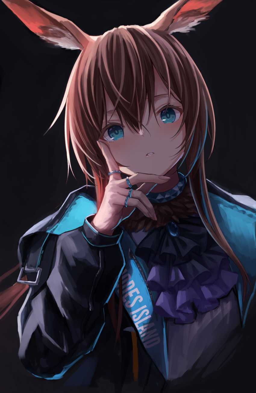 1girl amiya_(arknights) animal_ears arknights ascot bangs black_background black_jacket blue_eyes brown_hair bunny_ears choker english_commentary eyebrows_behind_hair hair_between_eyes hand_on_own_cheek hand_on_own_face hand_up highres jacket jewelry knoy3356 long_hair parted_lips ring simple_background solo upper_body