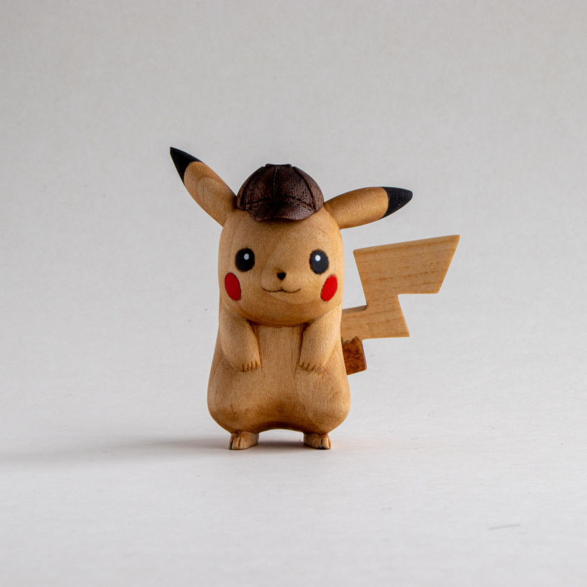 :3 absurdres black_eyes commentary deerstalker detective_pikachu detective_pikachu_(character) english_commentary gen_1_pokemon hat hatted_pokemon highres looking_at_viewer photo pikachu pokemon sculpture sean_syman shadow simple_background white_background