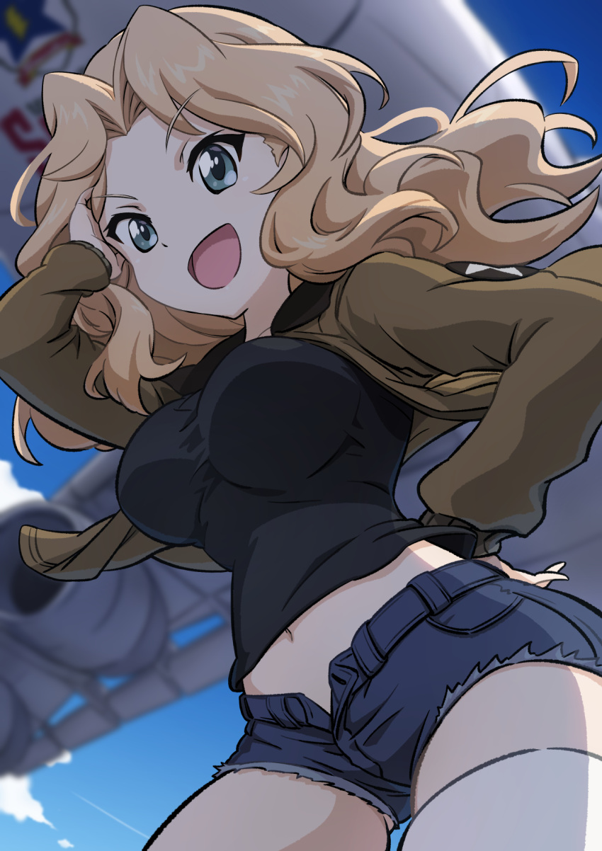 1girl aircraft airplane black_shirt blonde_hair blue_eyes blue_shorts blue_sky blurry blurry_background brown_jacket c-5m_super_galaxy cloud cloudy_sky commentary cowboy_shot cutoffs denim denim_shorts depth_of_field ehirorotoon emblem girls_und_panzer hair_intakes hand_in_own_hair hand_on_own_hip highres jacket kay_(girls_und_panzer) long_hair long_sleeves looking_at_viewer midriff military_uniform open_clothes open_fly open_jacket open_mouth saunders_(emblem) saunders_military_uniform shirt short_shorts shorts sky smile solo standing star_(symbol) thighhighs uniform white_thighhighs wind