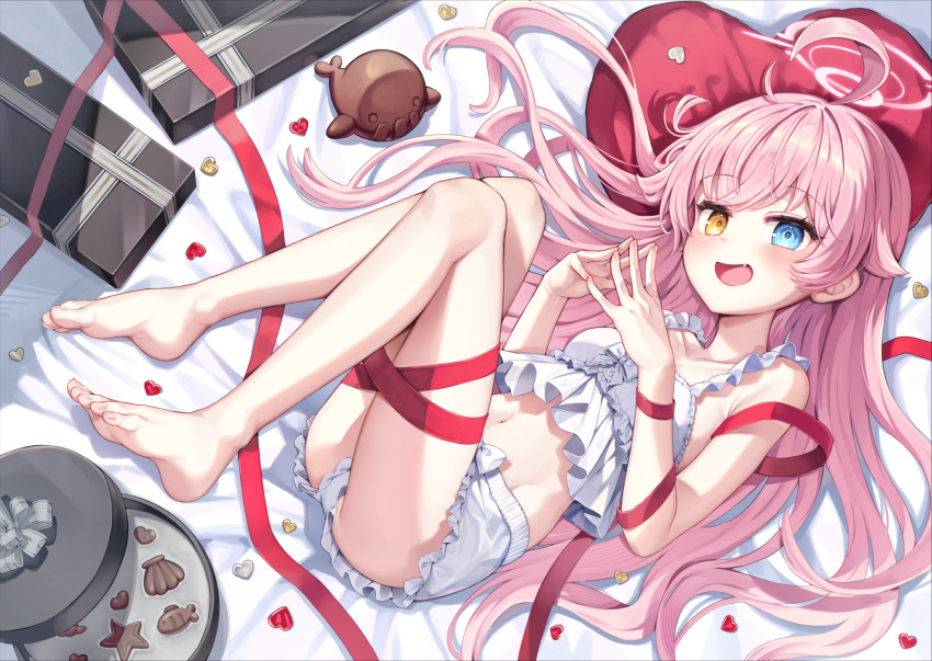 1girl :d ahoge bare_legs barefoot bloomers blue_archive blue_eyes chocolate commentary_request fang halo heart heart-shaped_pillow heterochromia highres hoshino_(blue_archive) legs looking_at_viewer lying midriff mono_(mono_mon) navel on_back open_mouth pillow pink_hair pink_halo smile solo toes valentine white_bloomers yellow_eyes