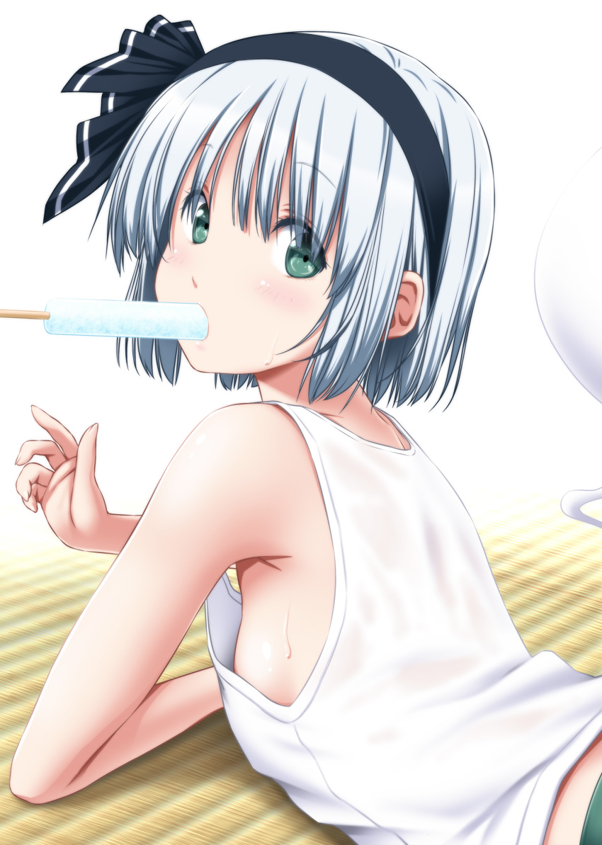1girl :o adapted_costume bangs bare_shoulders black_hairband black_ribbon blush breasts collarbone commentary_request eyebrows_visible_through_hair eyelashes food ghost green_eyes green_skirt hair_between_eyes hair_ribbon hairband highres hitodama hot indoors konpaku_youmu konpaku_youmu_(ghost) looking_at_viewer lying mouth_hold nori_tamago on_floor on_stomach open_mouth pleated_skirt popsicle ribbon short_hair sideboob silver_hair simple_background skirt small_breasts solo sweat tank_top tatami touhou upper_body white_background white_tank_top