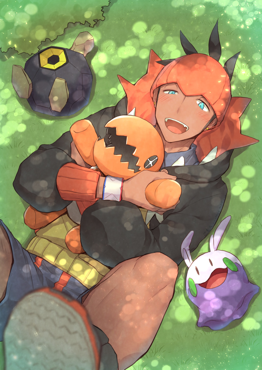 1boy aqua_eyes black_hair black_hoodie blush butabuhi commentary_request dark_skin dark_skinned_male dynamax_band earrings from_above gen_3_pokemon gen_5_pokemon gen_6_pokemon goomy grass highres holding holding_pokemon hood hood_down jewelry lying on_back open_mouth orange_headwear pokemon pokemon_(creature) pokemon_(game) pokemon_swsh raihan_(pokemon) roggenrola shorts smile teeth tongue trapinch