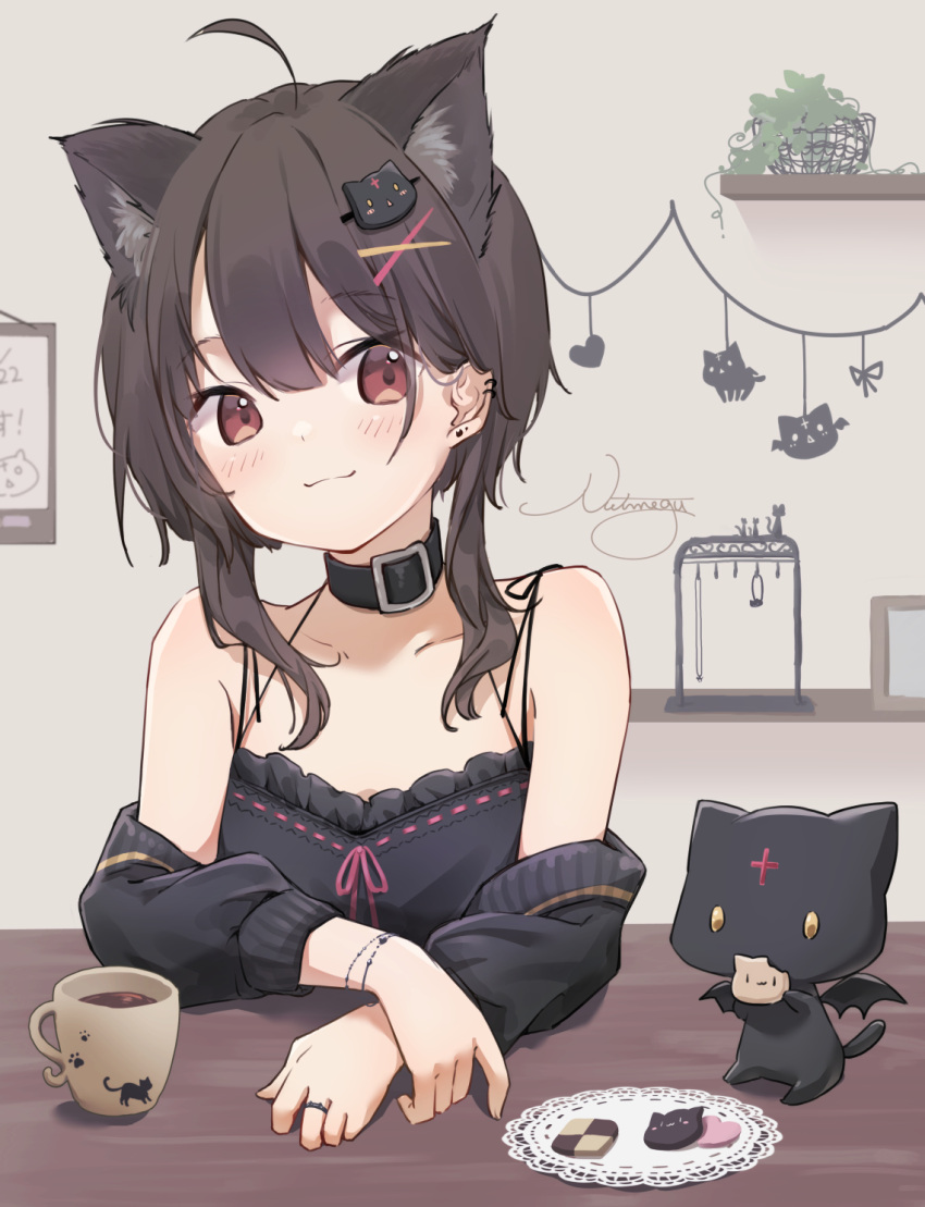 1girl :3 animal_ear_fluff animal_ears bare_shoulders blush bracelet brown_hair buckle camisole cat_ears cat_hair_ornament chomusuke closed_mouth collar collarbone commentary_request cookie creature cup detached_sleeves ear_piercing eating food hair_ornament highres jewelry kemonomimi_mode kono_subarashii_sekai_ni_shukufuku_wo! long_sleeves looking_at_viewer megumin nut_megu piercing red_eyes ring short_hair_with_long_locks sidelocks signature smile table upper_body