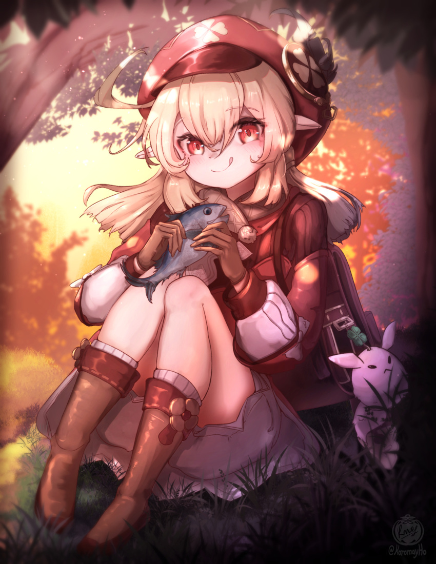 1girl ahoge backpack bag blonde_hair blush boots dress eating fish genshin_impact gloves grass hair_between_eyes hat_feather highres klee_(genshin_impact) knee_boots koromay_ho long_sleeves looking_at_viewer orange_sky outdoors pointy_ears red_dress red_eyes red_headwear sitting sky tree