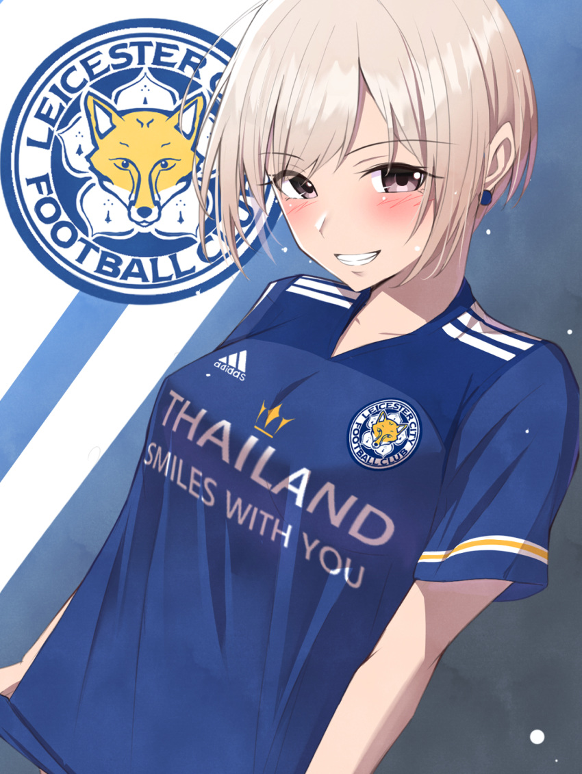 1girl adidas bangs blonde_hair blue_background blue_shirt blush breasts brown_eyes clothes_writing collarbone commentary_request earrings eyebrows_visible_through_hair grin highres idolmaster idolmaster_cinderella_girls jewelry k-chitsu leicester_city_fc logo looking_at_viewer medium_breasts parted_bangs shiomi_shuuko shirt short_hair short_sleeves sidelocks smile soccer_uniform solo sportswear standing teeth trait_connection two-tone_background upper_body white_background