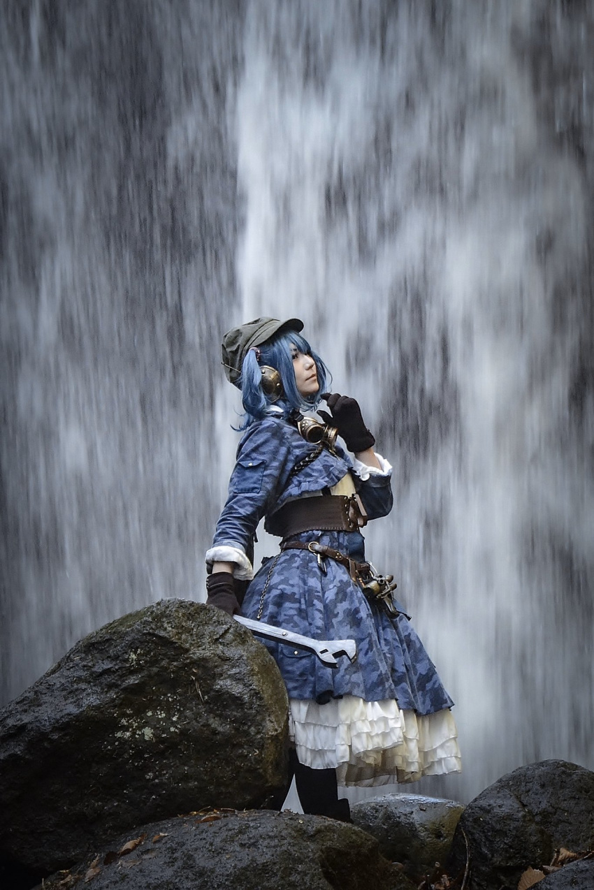1girl adapted_costume blue_hair blue_shirt blue_skirt brown_gloves closed_mouth cosplay from_side gloves hat highres holding holding_wrench kawashiro_nitori kawashiro_nitori_(cosplay) layered_skirt long_sleeves mametacos photo_(medium) shirt skirt solo standing tool_belt touhou water waterfall wrench