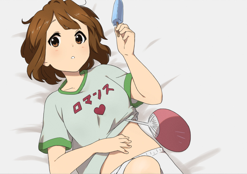 1girl bangs brown_eyes brown_hair commentary_request food from_above grey_shirt hand_fan hand_on_own_stomach hand_up heart highres hirasawa_yui holding holding_food k-on! kicchi_(tmgk) looking_at_viewer lying midriff_peek on_back on_bed parted_lips popsicle shirt short_hair short_sleeves shorts solo t-shirt teeth translated upper_body white_shorts