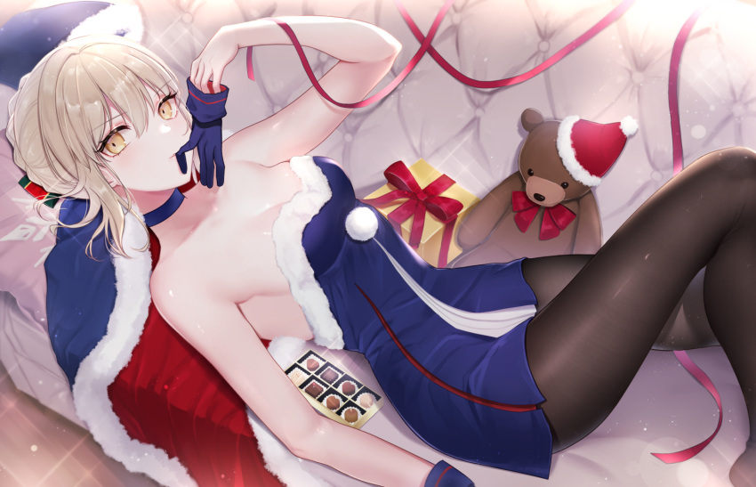 1girl artoria_pendragon_(fate) bangs bare_arms bare_shoulders biting black_legwear blonde_hair blush bobblehat box box_of_chocolates breasts choker cleavage couch dress eyebrows_visible_through_hair fate/grand_order fate_(series) feet_out_of_frame fur-trimmed_dress fur-trimmed_headwear fur_trim gift gift_box glove_biting glove_in_mouth gloves gloves_removed hat knee_up looking_at_viewer lying meltymaple mouth_hold on_back on_couch pantyhose pillow purple_choker purple_dress purple_gloves red_headwear removing_glove revision santa_alter santa_hat short_dress short_hair small_breasts solo sparkle strapless strapless_dress stuffed_animal stuffed_toy teddy_bear yellow_eyes
