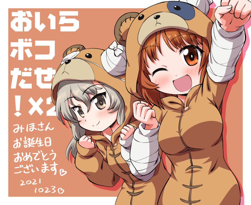 2girls ;d animal_costume bangs bear_costume birthday boko_(girls_und_panzer) border brown_background brown_eyes brown_hair clenched_hands closed_mouth commentary dated eyebrows_visible_through_hair girls_und_panzer happy_birthday highres inoue_kouji light_blush light_brown_hair long_hair looking_at_viewer multiple_girls nishizumi_miho one_eye_closed outside_border raised_fist shimada_arisu short_hair smile standing translated white_border