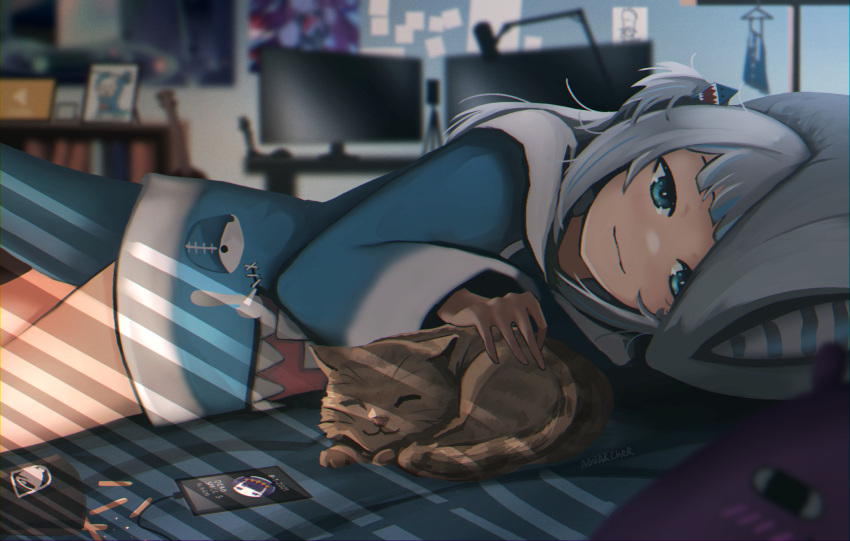 1girl animal_costume animal_hood anonamos artist_name bangs bed bed_sheet bedroom blue_eyes blue_hoodie blunt_bangs blurry blurry_background brown_cat cat cellphone fish_tail gawr_gura hair_ornament highres hololive hololive_english hood hoodie indoors long_sleeves looking_at_viewer lying medium_hair microphone monitor multicolored_hair on_stomach petting phone pillow shark_costume shark_girl shark_hair_ornament shark_hood shark_tail silver_hair smile streaked_hair tail virtual_youtuber