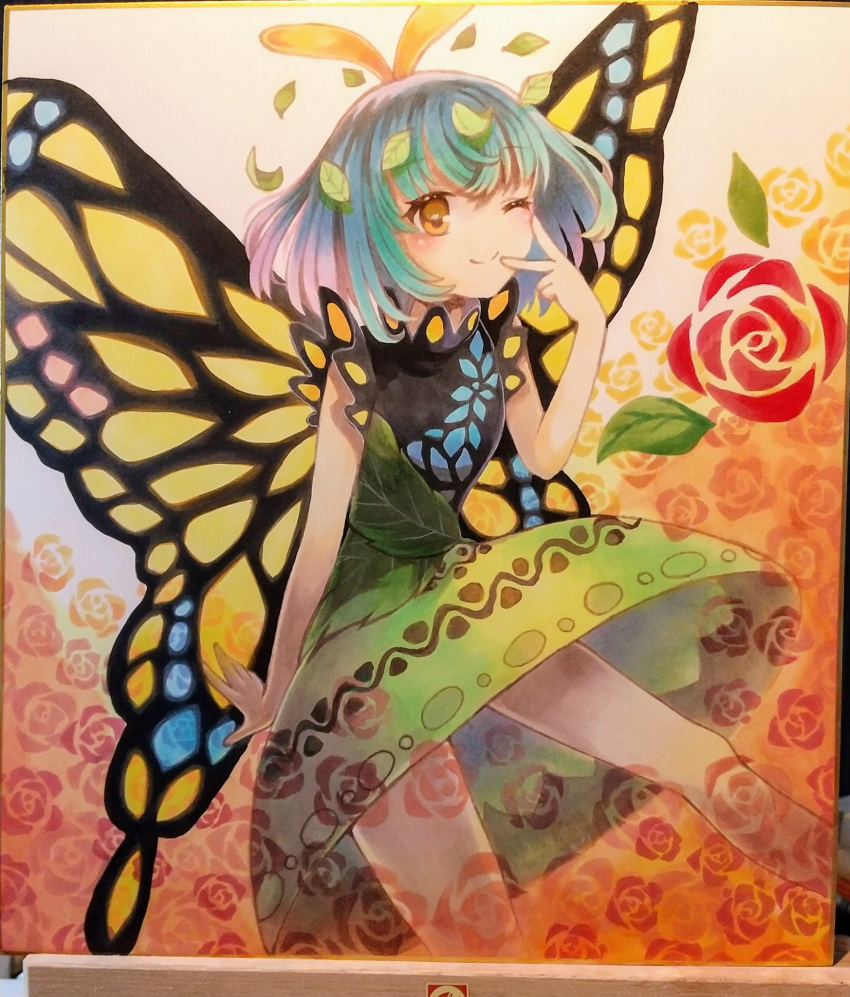 1girl antennae aqua_hair butterfly_wings closed_mouth dress eternity_larva eyebrows_visible_through_hair fairy green_dress hair_between_eyes highres leaf leaf_on_head multicolored_clothes multicolored_dress one_eye_closed orange_eyes photo_(medium) proton shikishi short_hair short_sleeves single_strap smile solo touhou wings