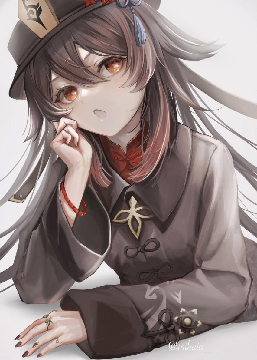 1girl absurdres arm_support black_headwear black_jacket black_nails bracelet brown_hair chinese_clothes commentary eyelashes flat_chest flower flower-shaped_pupils flower_knot genshin_impact grey_background hair_between_eyes hand_on_own_face hat hat_flower highres hu_tao_(genshin_impact) jacket jewelry long_hair long_sleeves looking_at_viewer lying mihaia multicolored_hair multiple_rings nail_polish on_stomach open_mouth porkpie_hat red_eyes red_hair red_shirt ring shirt simple_background solo symbol-shaped_pupils tangzhuang tassel twitter_username two-tone_hair upper_body