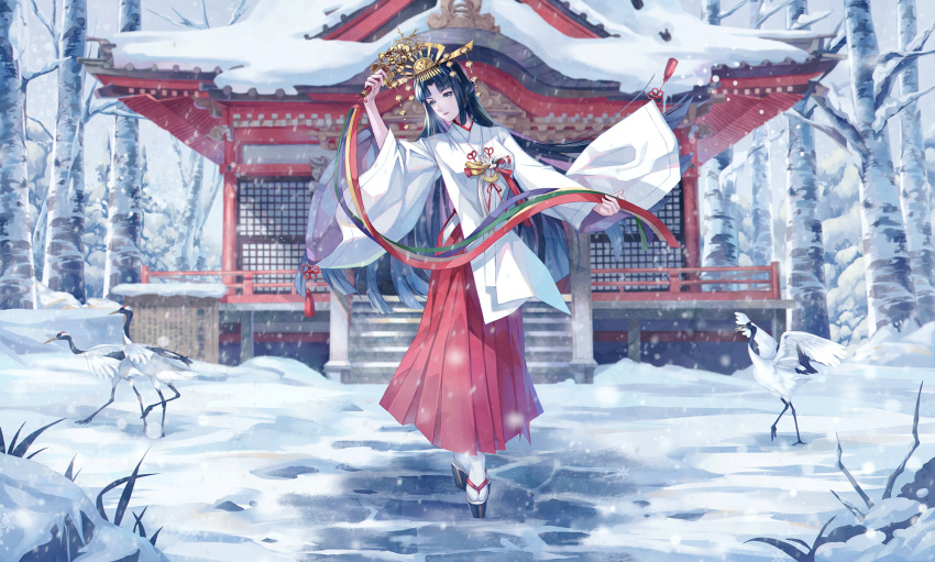 1girl bangs bell black_hair commentary commentary_request crown december hakama hakama_skirt highres hime_cut holding japanese_clothes jingle_bell kagura_suzu long_hair looking_at_viewer miko original personification red_hakama ryuu32 shrine skirt smile snow solo