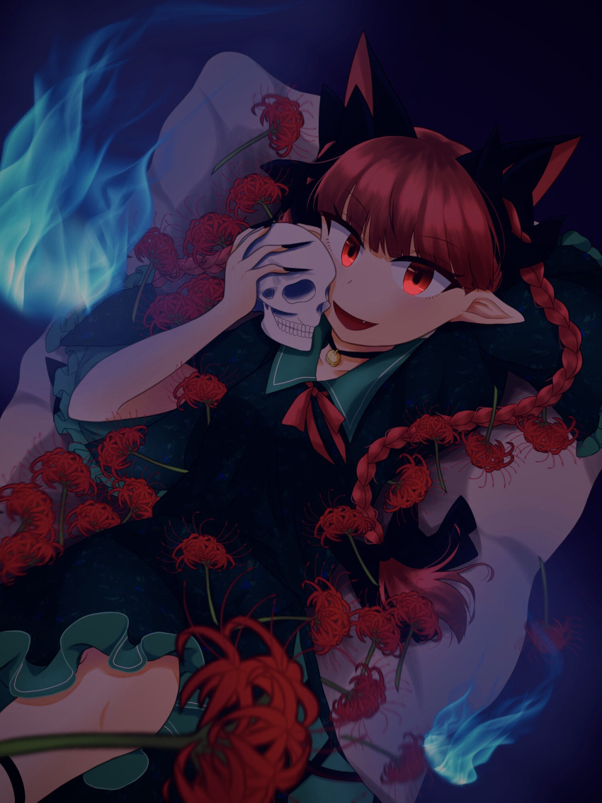 1girl :d animal_ears bangs blue_fire blunt_bangs bow braid cat_ears choker cosmos_0131 dark dress extra_ears feet_out_of_frame fire flower frills green_dress hair_bow highres hitodama holding holding_skull kaenbyou_rin leg_ribbon long_hair looking_at_viewer lying multiple_tails on_back open_mouth pointy_ears puffy_sleeves red_eyes red_flower red_hair ribbon skull smile solo spider_lily tail touhou twin_braids