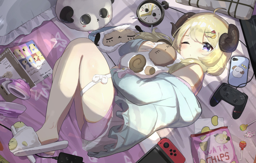 1girl ahoge alarm_clock blonde_hair candy candy_wrapper chips clock closed_mouth commentary_request controller dolphin_shorts food fruit_hair_ornament game_controller hair_ornament hairclip headphones highres hololive hood hoodie horns lollipop looking_at_viewer lying medium_hair nintendo_switch object_hug on_bed on_side one_eye_closed pajamas pillow potato_chips purple_eyes sheep_horns shorts slippers solo stuffed_animal stuffed_sheep stuffed_toy tatedano_kabae thigh_strap thighs tsunomaki_watame virtual_youtuber waking_up