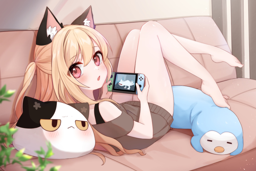 1girl absurdres animal_ear_fluff animal_ears atsuki_(pink0930cat) bangs bare_arms bare_legs barefoot blonde_hair blush cat_ears chestnut_mouth controller couch half_updo highres holding holding_controller khezu knees_up legs_up long_hair looking_at_viewer looking_back lying monster_hunter_(series) nintendo_switch off-shoulder_sweater off_shoulder on_back on_couch open_mouth original pink_eyes short_sleeves solo stuffed_animal stuffed_cat stuffed_penguin stuffed_toy sweater video_game