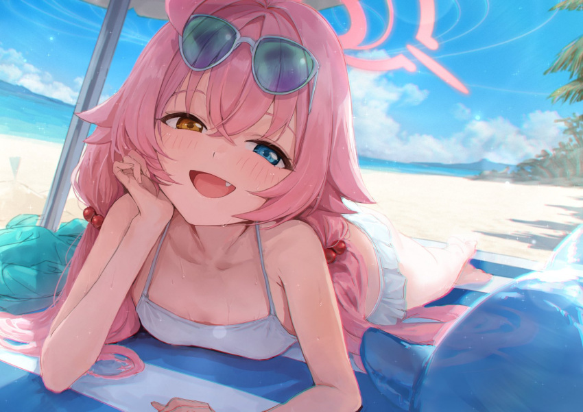 1girl akita_hika bare_arms bare_shoulders beach beach_towel beach_umbrella bikini blue_archive blue_eyes blue_sky cloud commentary day eyewear_on_head fang foreshortening hair_bobbles hair_ornament halo hand_on_own_cheek hand_on_own_face head_rest heterochromia highres hoshino_(blue_archive) hoshino_(swimsuit)_(blue_archive) long_hair looking_at_viewer lying official_alternate_costume on_stomach open_mouth orange_eyes outdoors palm_tree pink_hair pink_halo sand shade sky smile solo sunglasses sweat swimsuit towel tree umbrella wet white_bikini