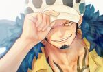  1boy adjusting_clothes adjusting_headwear black_hair chest_tattoo close-up facial_hair feather_boa goatee grin highres jaguar_print long_sideburns male_focus one_eye_closed one_piece rotated short_hair sideburns smile solo tattoo toyoura_(23066494) trafalgar_law upper_body 