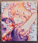  1girl arms_up bed_sheet blonde_hair blush breasts cleavage commentary dress elbow_gloves frills gloves hair_between_eyes hair_ribbon hat large_breasts long_hair looking_at_viewer lying masanaga_(tsukasa) mob_cap on_back parted_lips photoshop_(medium) puffy_short_sleeves puffy_sleeves purple_dress purple_eyes ribbon short_sleeves solo touhou traditional_media untranslatable_commentary upper_body white_gloves yakumo_yukari 