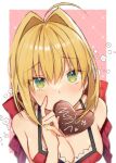  1girl ahoge ayaka_(disagree) bangs blonde_hair border bow breasts candy chocolate cleavage eyebrows_visible_through_hair fate/extra fate_(series) food green_eyes hair_between_eyes hair_bow hair_intakes heart heart-shaped_chocolate highres looking_at_viewer medium_breasts mouth_hold nero_claudius_(fate) nero_claudius_(fate/extra) outside_border pink_background red_bow shiny shiny_hair short_hair solo upper_body white_border 