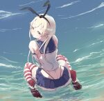  1girl beach black_hairband black_panties blonde_hair blue_sailor_collar crop_top elbow_gloves from_behind gloves grey_eyes hairband highleg highleg_panties kantai_collection long_hair looking_at_viewer looking_back microskirt miniskirt n-mori panties partially_submerged rudder_footwear sailor_collar shimakaze_(kancolle) sitting skirt solo striped striped_legwear thighhighs underwear wariza water white_gloves 