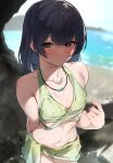  1girl beach bikini blurry blurry_background breasts dark_blue_hair flat_chest green_bikini highres idolmaster idolmaster_shiny_colors jewelry karan looking_at_viewer medium_breasts morino_rinze navel necklace polka_dot polka_dot_bikini red_eyes rock smile solo swimsuit water_drop wet wet_hair 