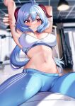  1girl ahoge armpits arms_up bangs blue_hair blue_pants blurry blurry_background blush breasts cleavage commentary_request crop_top english_commentary ganyu_(genshin_impact) genshin_impact hair_between_eyes highres horns indoors leggings long_hair looking_at_viewer midriff navel pants parted_lips purple_eyes sitting solo sports_bra squchan stomach thighs very_long_hair 